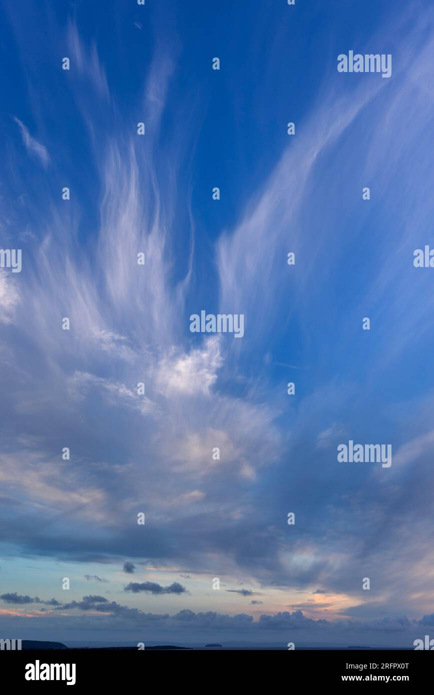 Wispy nuvole contro un cielo blu Foto Stock
