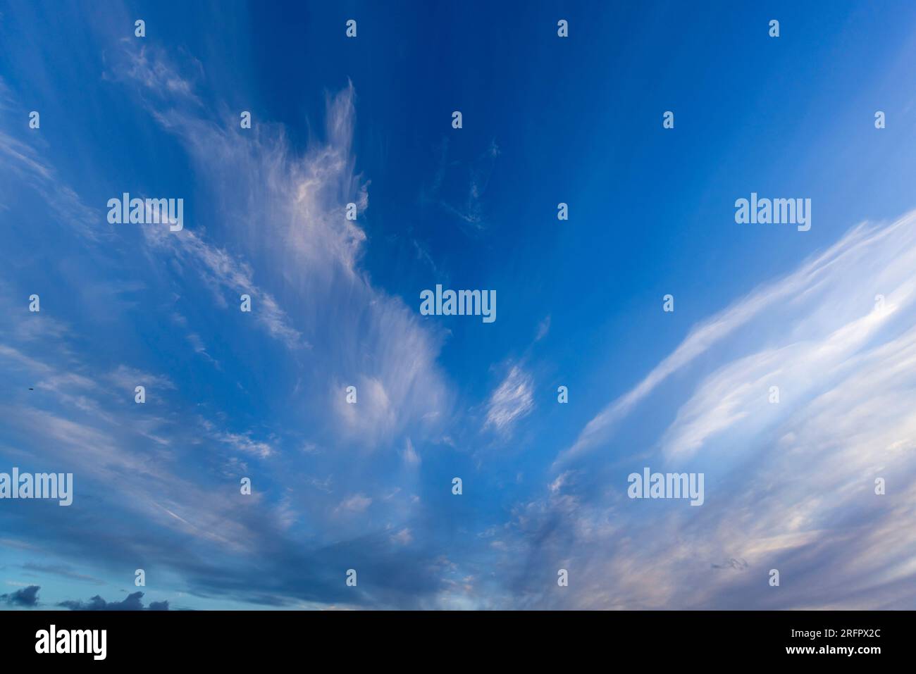 Wispy nuvole contro un cielo blu Foto Stock