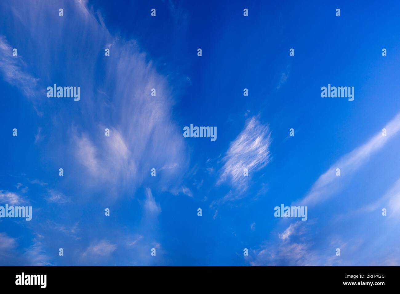 Wispy cirrus nuvole contro un cielo blu Foto Stock