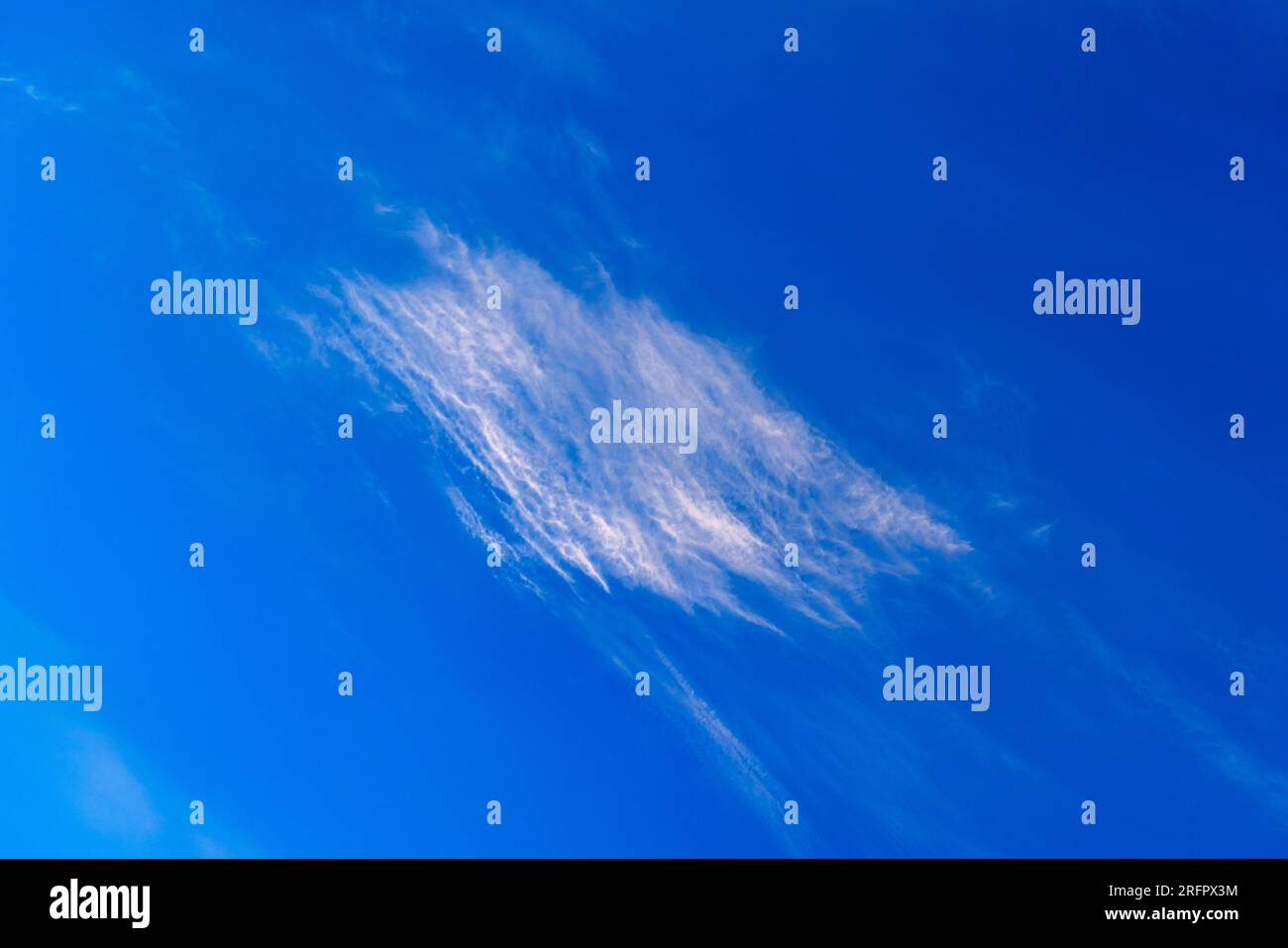 Wispy cirrus nuvole contro un cielo blu Foto Stock