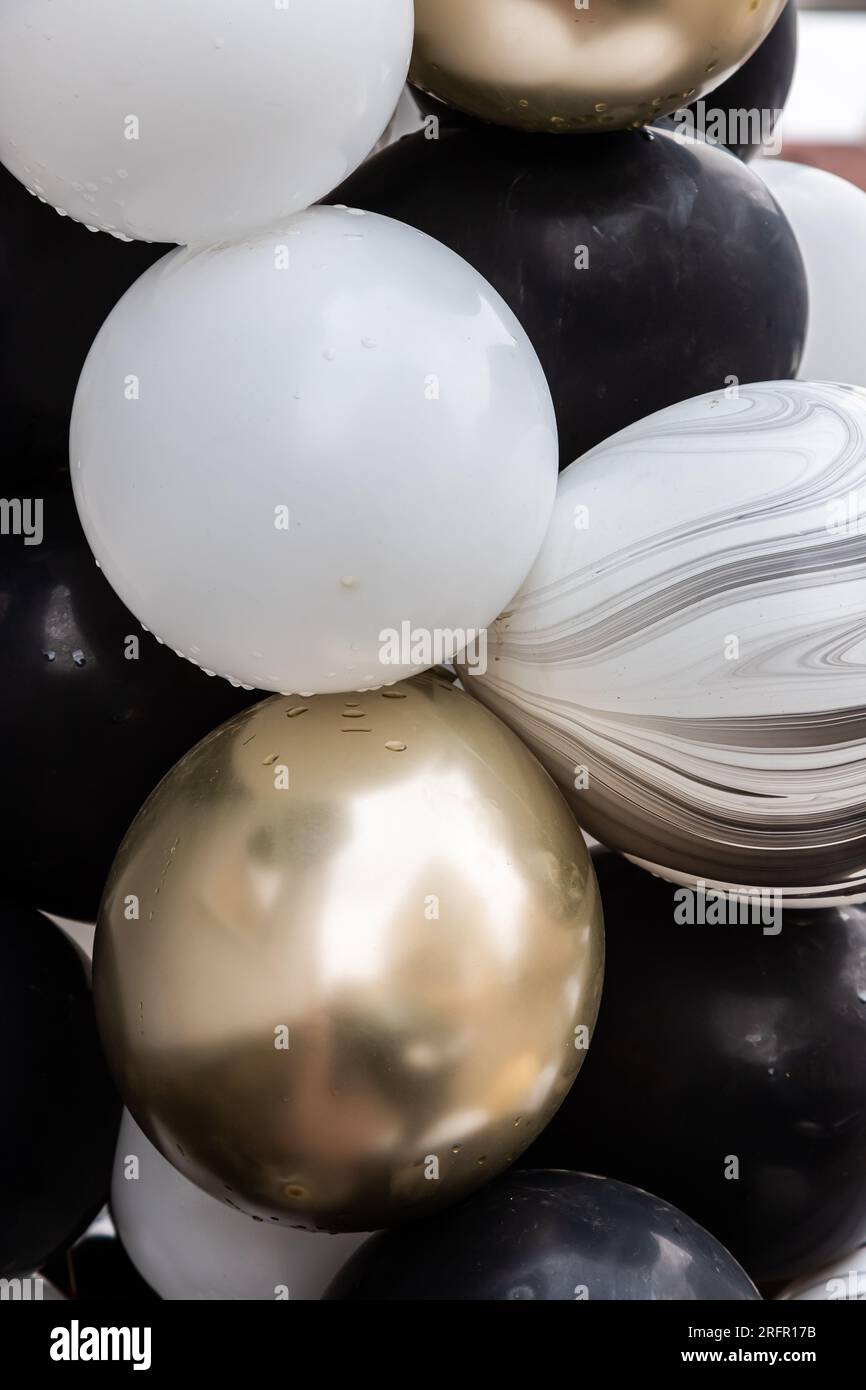 palloncini nero, argento e oro. primo piano sullo sfondo. Foto Stock