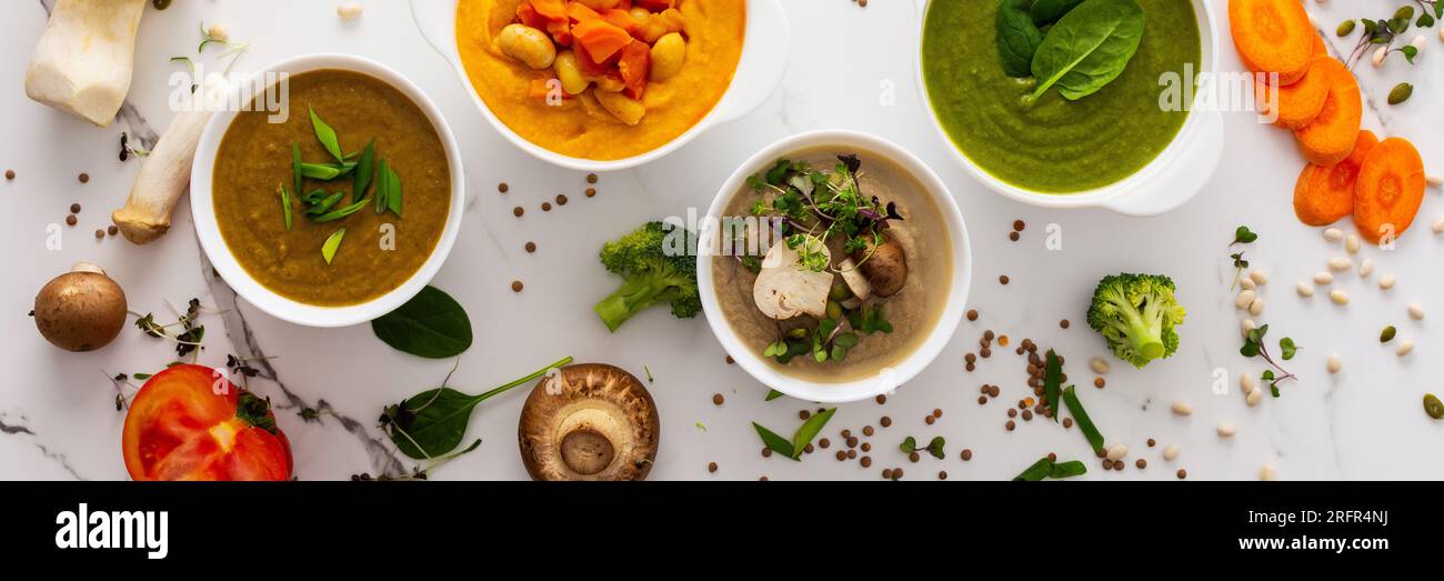Zuppa di crema di funghi e lenticchie, fagioli, zuppa di carote e pomodori, broccoli e zuppa di spinaci su sfondo bianco con striscione degli ingredienti da cucina Foto Stock