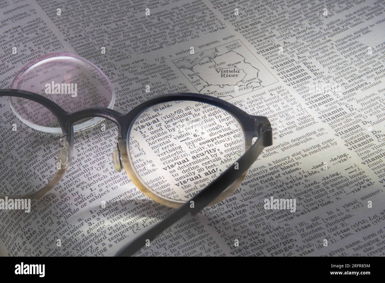 STILL Life di un paio di occhiali da vista con una lente mancante in cima a un dizionario inglese, 2023, USA Foto Stock