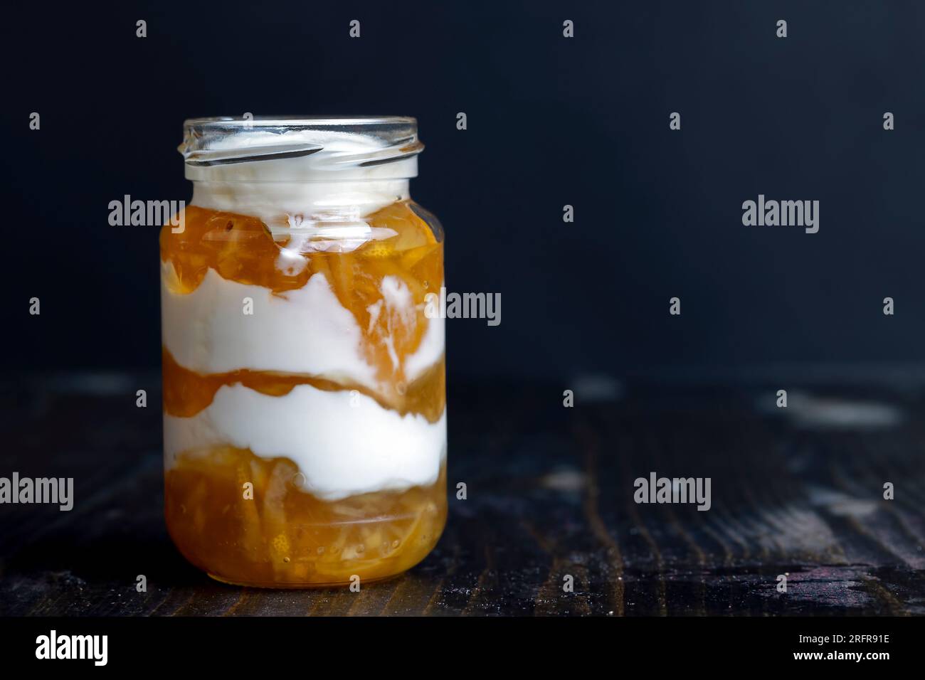 Yogurt a base di latte fresco con l'aggiunta di marmellata di limone dolce e limoni freschi , delizioso yogurt dal sapore di limone Foto Stock