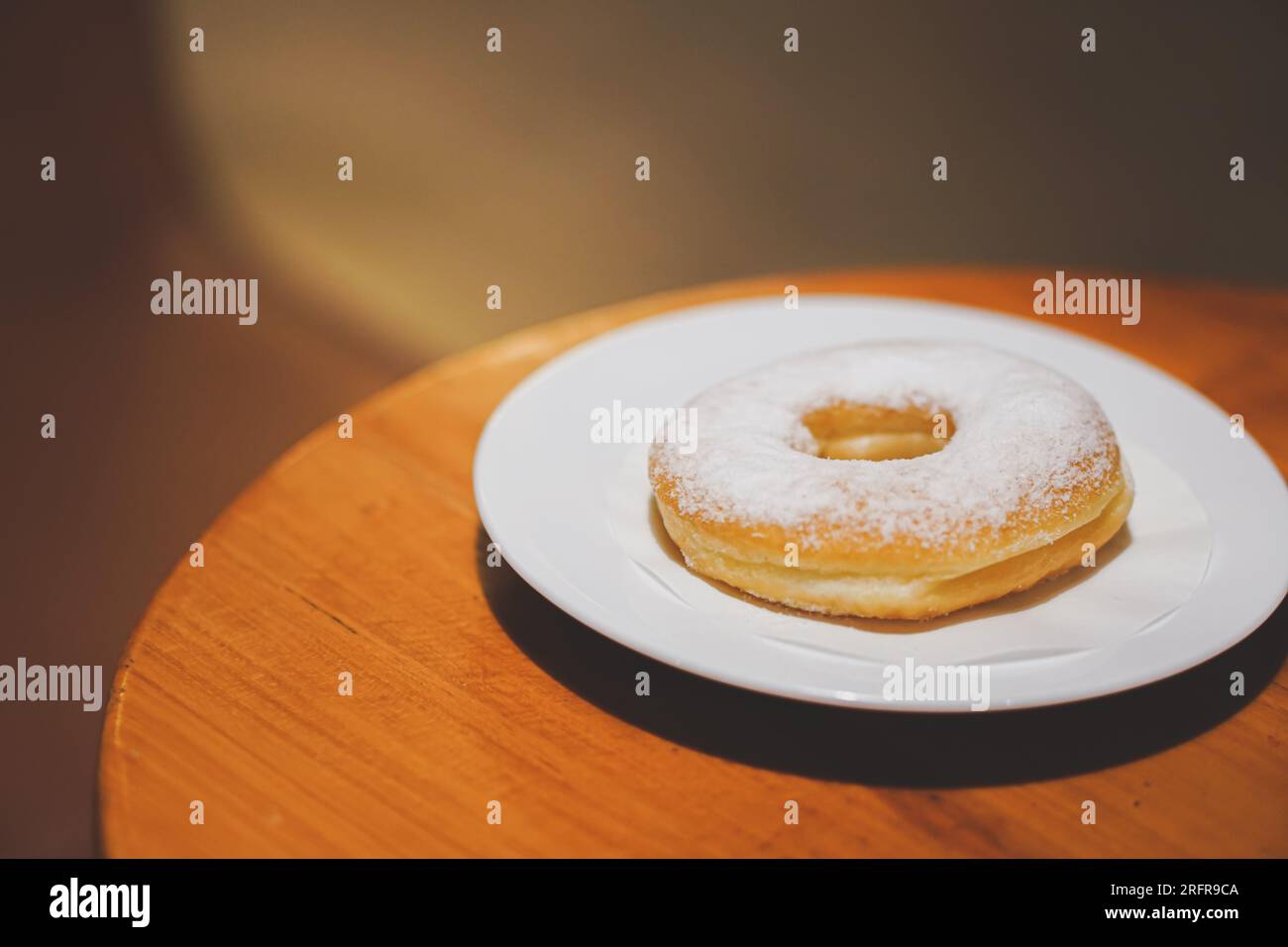 Ciambelle jco e jco chino con una grande tazza, su un tavolo di legno marrone Foto Stock