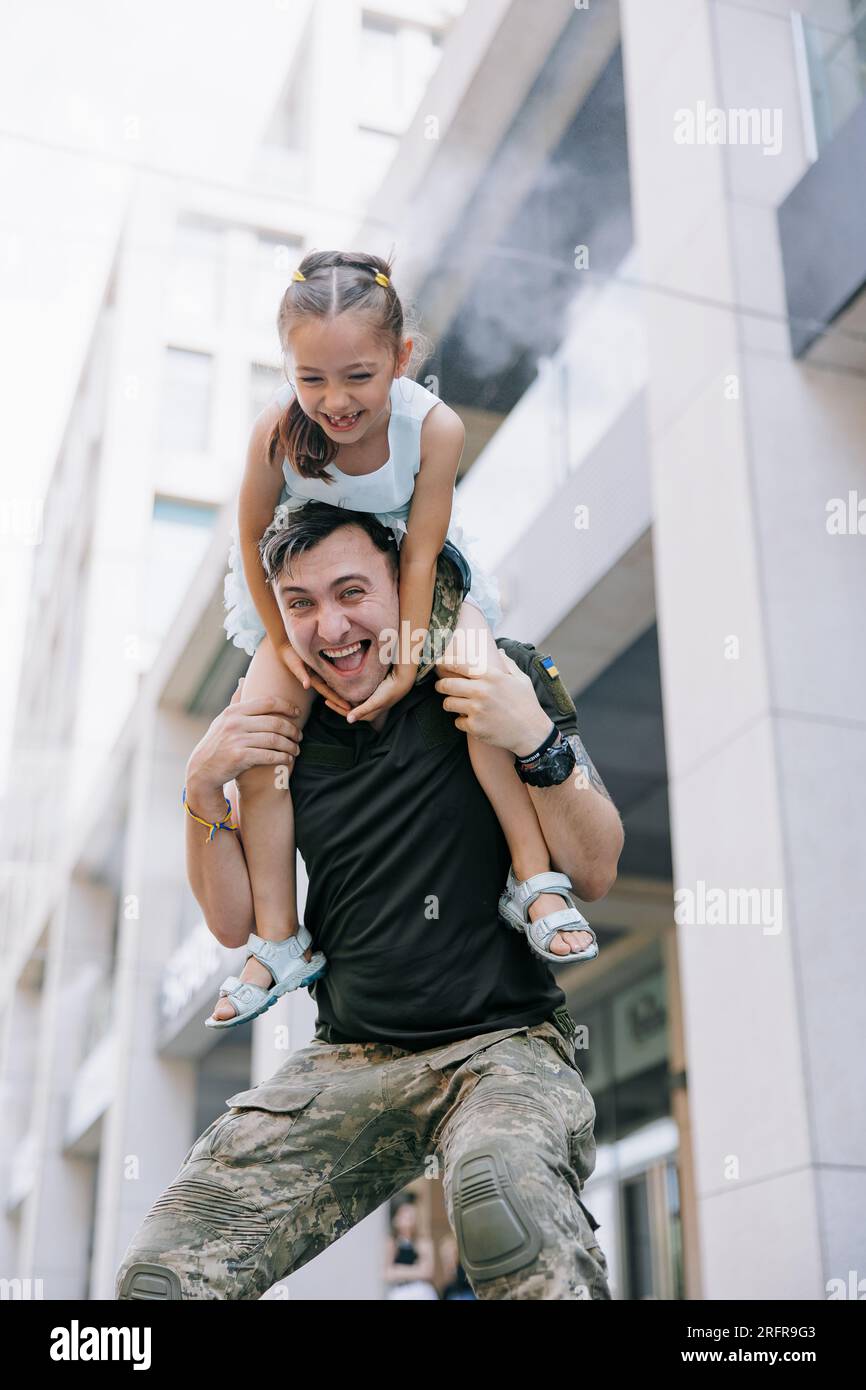 La bambina Ucraina incontra suo padre durante la guerra durante le sue vacanze e gioisce allegramente con lui. Guerra in Ucraina. Invasione militare russa a Ukra Foto Stock