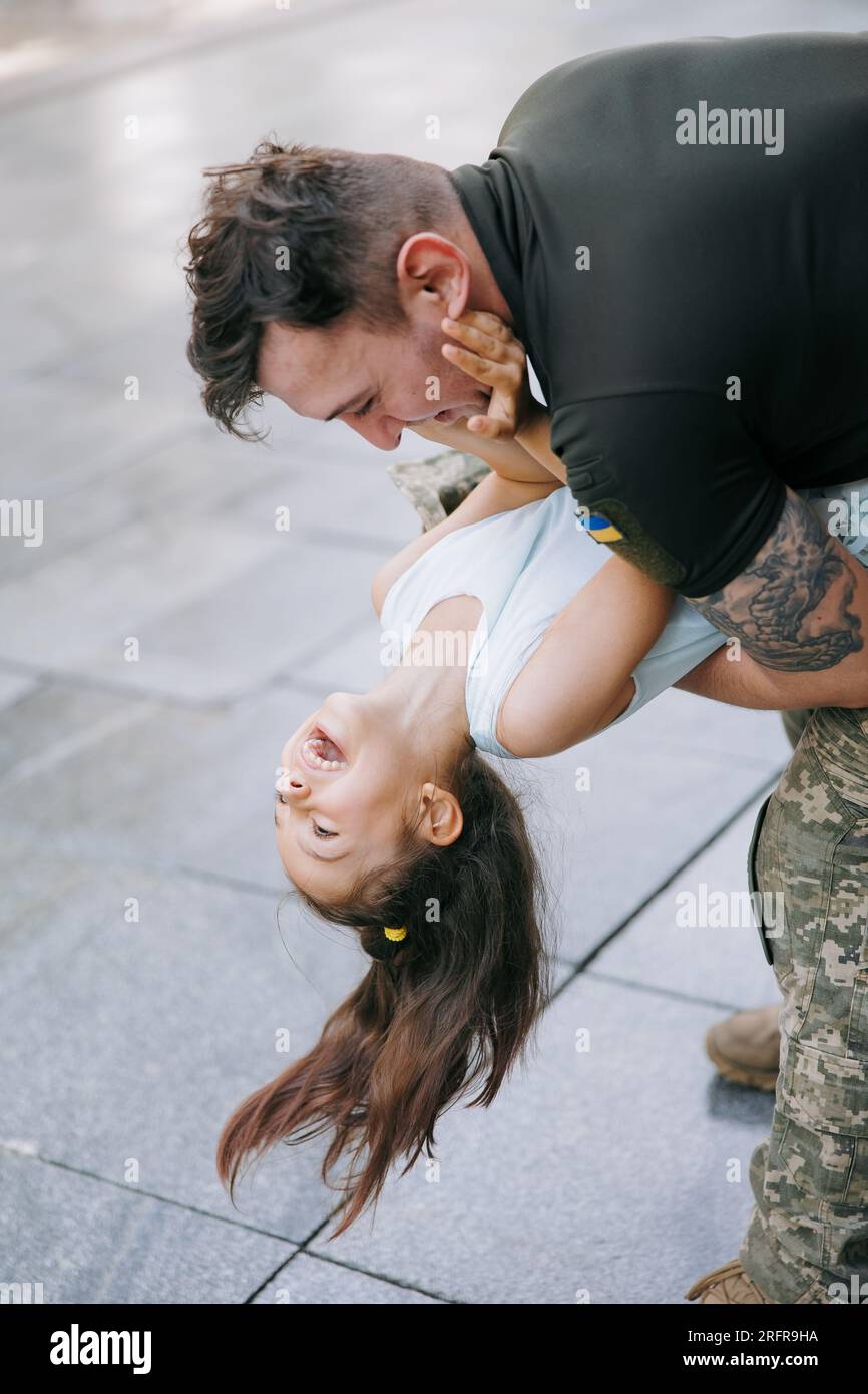 La bambina Ucraina incontra suo padre durante la guerra durante le sue vacanze e gioisce allegramente con lui. Guerra in Ucraina. Invasione militare russa a Ukra Foto Stock