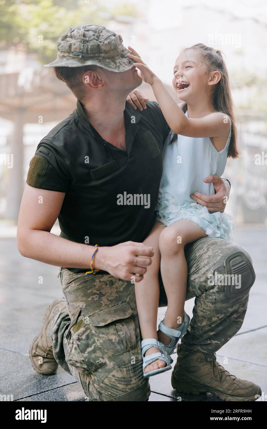 La bambina Ucraina incontra suo padre durante la guerra durante le sue vacanze e gioisce allegramente con lui. Guerra in Ucraina. Invasione militare russa a Ukra Foto Stock