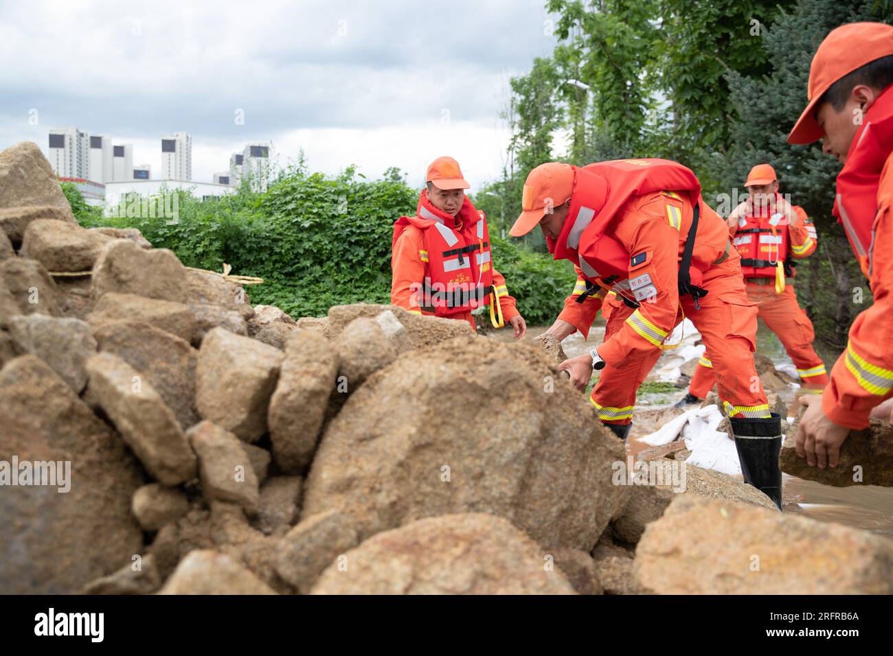 (230805) -- HARBIN, 5 agosto 2023 (Xinhua) -- i vigili del fuoco trasferiscono rocce per bloccare le inondazioni vicino al villaggio di Dawan del distretto di Dong'an, Mudanjiang, provincia di Heilongjiang nella Cina nordorientale, 5 agosto 2023. Innescato da piogge torrenziali nella città di Mudanjiang e nella capitale provinciale Harbin, i livelli dell'acqua di alcuni fiumi hanno superato il livello dell'acqua di avvertimento. Squadre di soccorso di emergenza, tra cui vigili del fuoco locali e vigili del fuoco forestale, sono stati inviati per aiutare con il lavoro di soccorso e soccorso. Le pattuglie di 24 ore sugli argini sono state condotte per controllare i rischi, e le inondazioni colpite r Foto Stock