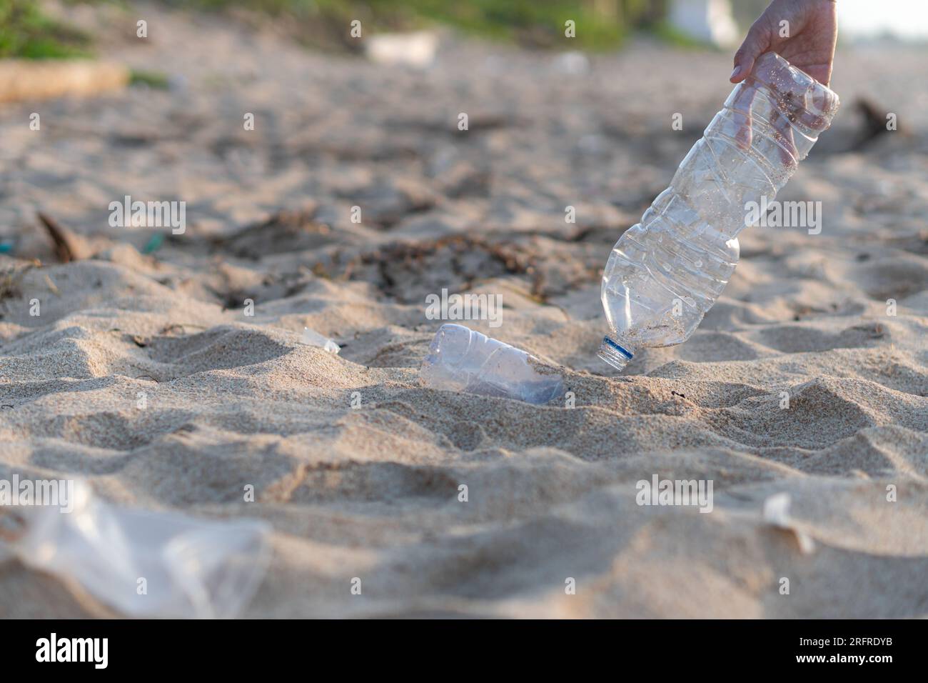 Raccolta volontaria di bottiglie di plastica per la pulizia giornaliera, raccolta di rifiuti sulla spiaggia di mare, inquinamento e concetto di riciclaggio Foto Stock