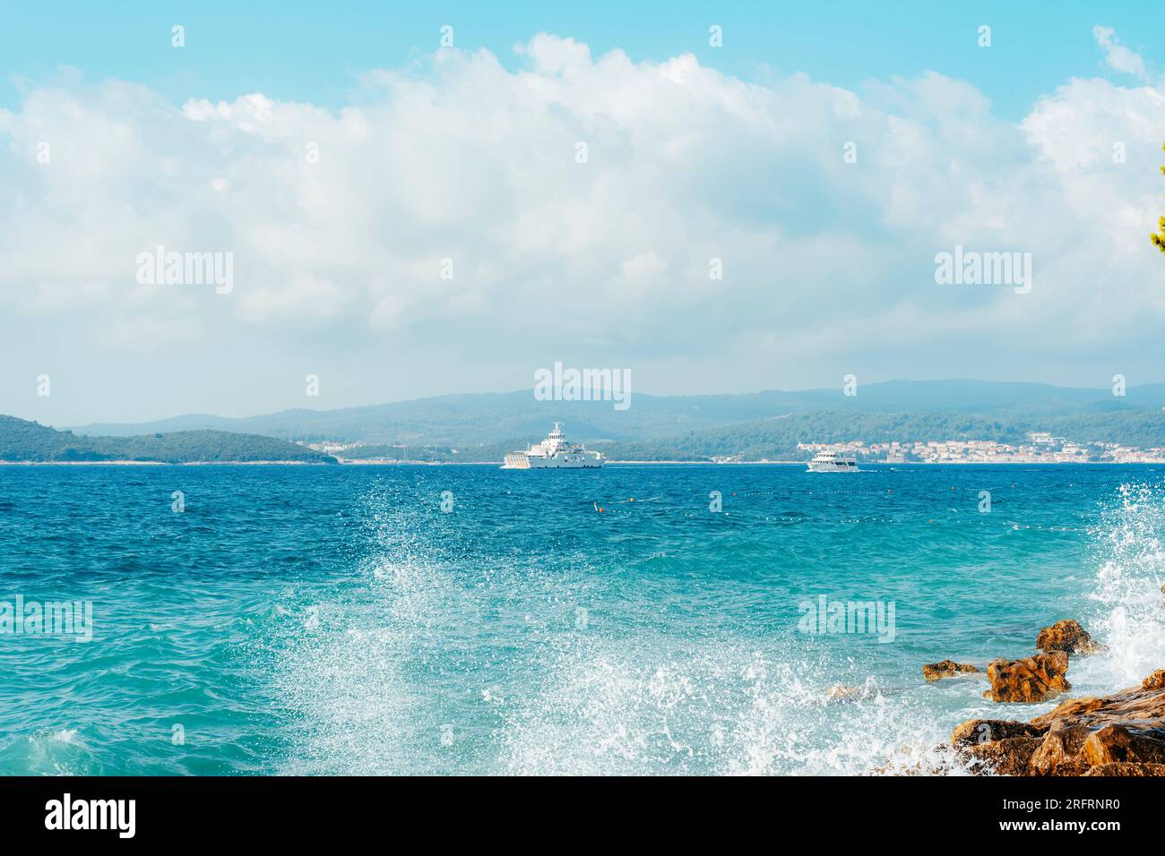 La nave naviga lungo la riva con le montagne. Peljesac, Croazia. Foto Stock