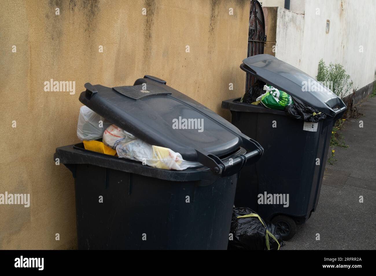 Slough, Berkshire, Regno Unito. 3 agosto 2023. Bidoni e sacchetti neri fuori casa a Slough, Berkshire. Slough Borough Council (SBC) ha recentemente introdotto una modifica alle collezioni di cestini dei residenti al fine di incoraggiare i residenti a riciclare di più. I contenitori grigi con rifiuti generici, compreso il cibo, vengono ora raccolti una volta ogni due settimane piuttosto che una volta alla settimana, con il riciclaggio in contenitori rossi, che vengono raccolti nella settimana alternata. Alcuni residenti di Slough stanno ora segnalando problemi con i vermi e gli odori di rifiuti non raccolti lasciati sulle strade, che probabilmente peggioreranno solo una volta che le temperature Foto Stock