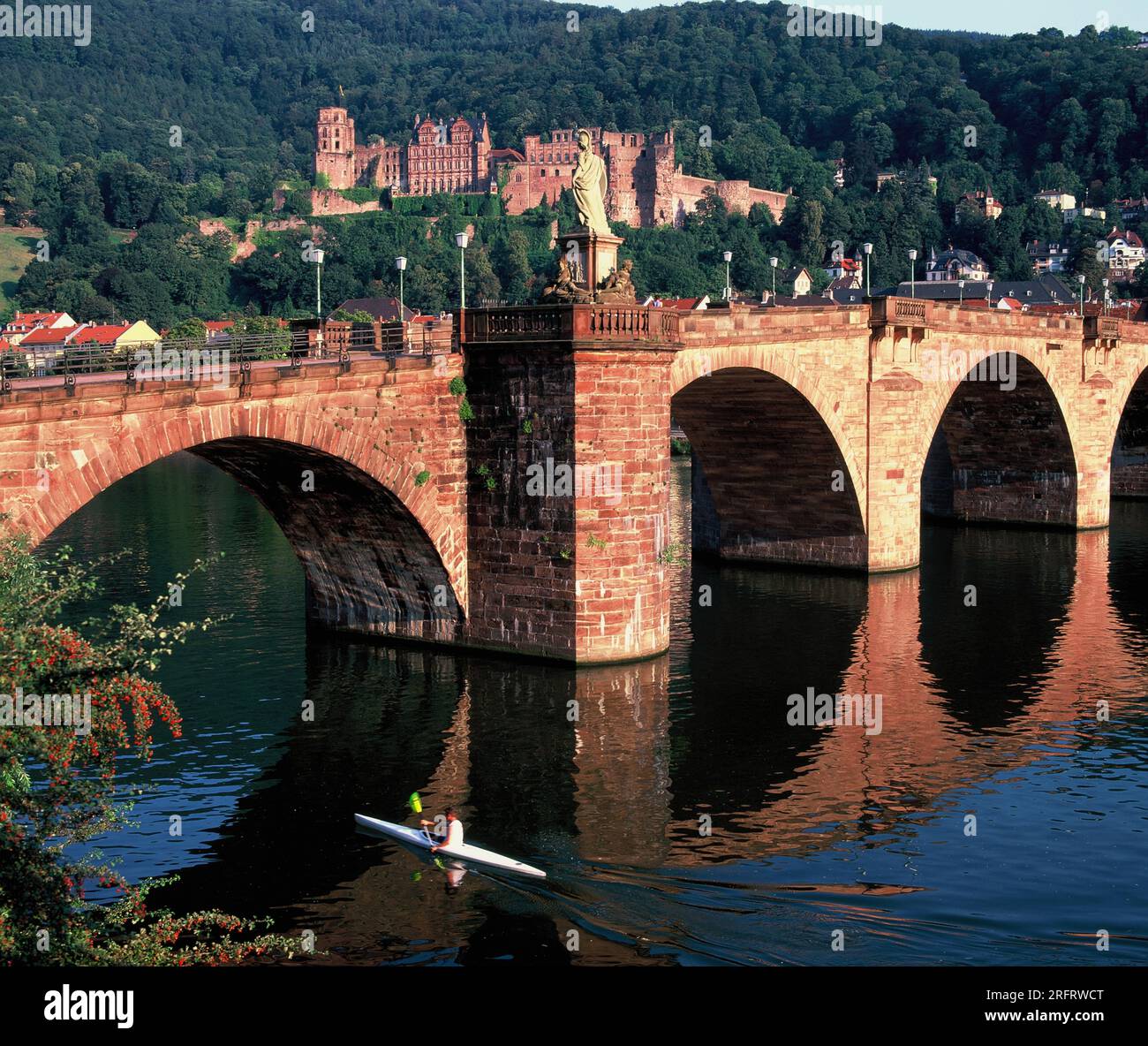 Germania. Heidelberg. Ponte sul fiume Neckar nel tardo pomeriggio. Canoista sul fiume. Foto Stock