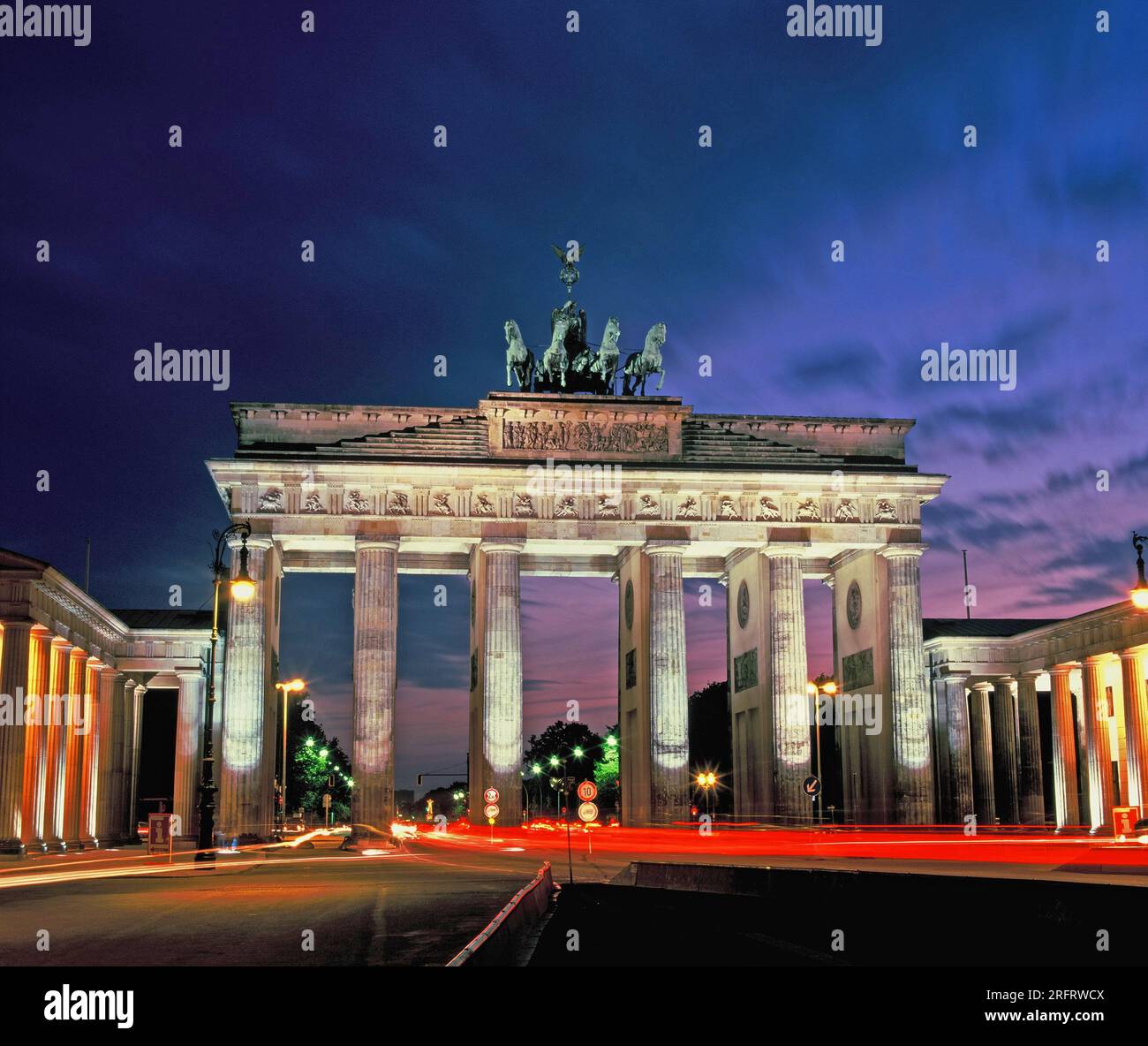 Germania. Berlino. Porta di Brandeburgo. Vista notturna con strisce di luci posteriori per auto. Foto Stock