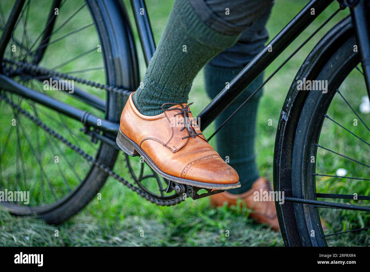 Uomo che indossa scarpe in pelle marrone con dettagli di primo piano sulle biciclette d'epoca Foto Stock