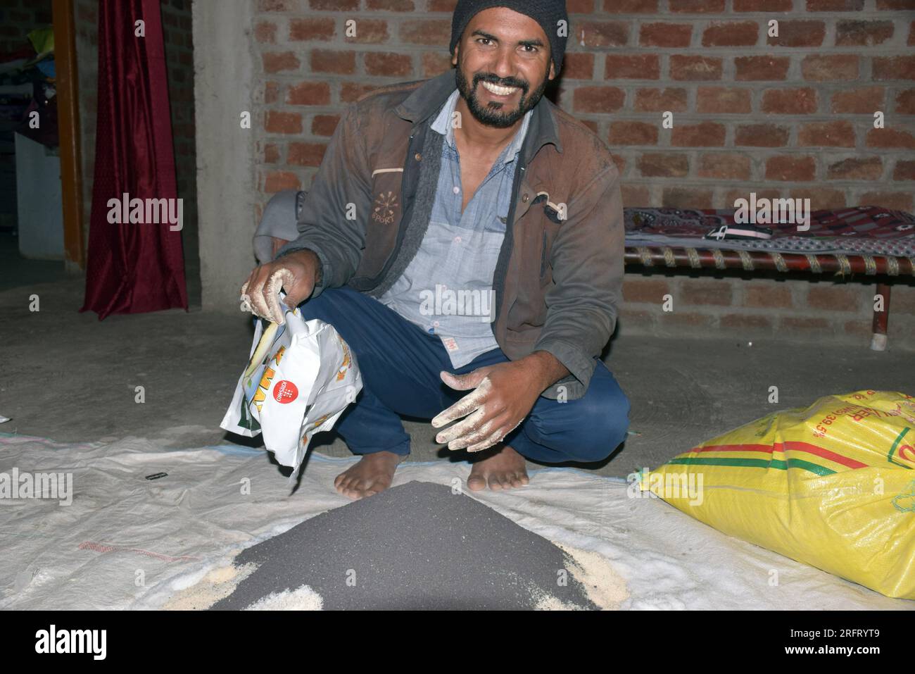 09-12-2021 Indore, Madhya Pradesh, India. Agricoltore indiano che mescola diversi elementi fertilizzanti nel letame, a casa. messa a fuoco selettiva Foto Stock