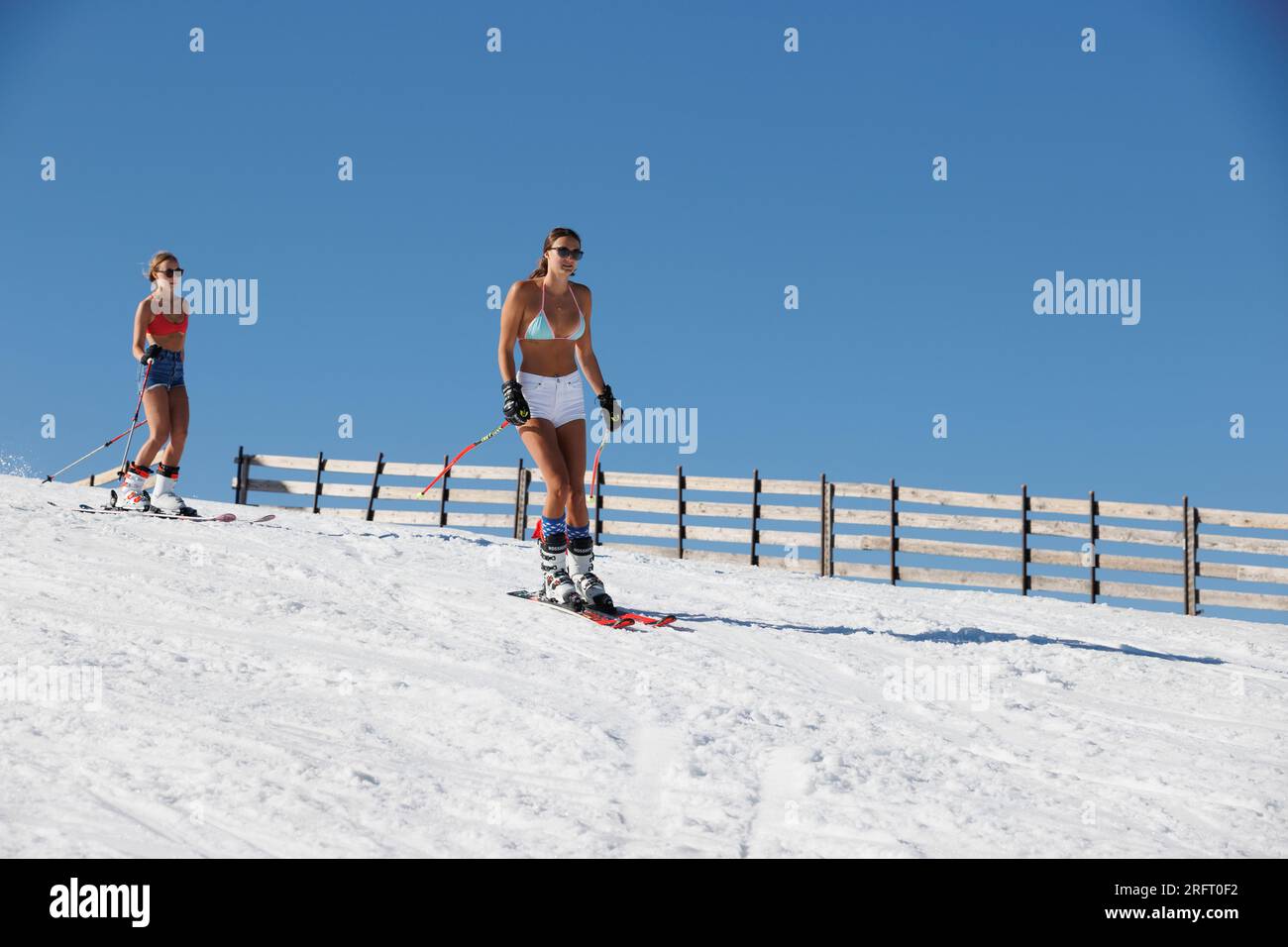 Mammoth Lakes, CA. 4 luglio 2023. Due giovani donne in bikini Top sciano al sole al Mammoth Mountain Ski Resort in una chiara giornata estiva. Foto Stock