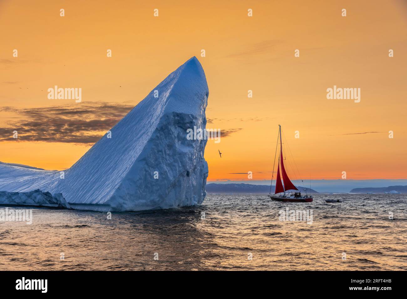 Vele rosse all'iceberg delle pinne di squalo durante il tramonto, Disko Bay, Groenlandia Foto Stock