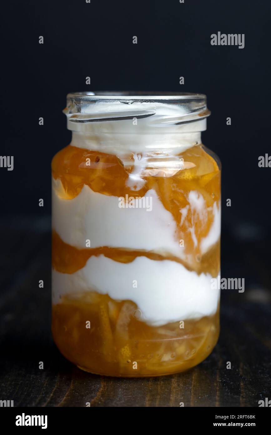 Yogurt a base di latte fresco con l'aggiunta di marmellata di limone dolce e limoni freschi , delizioso yogurt dal sapore di limone Foto Stock