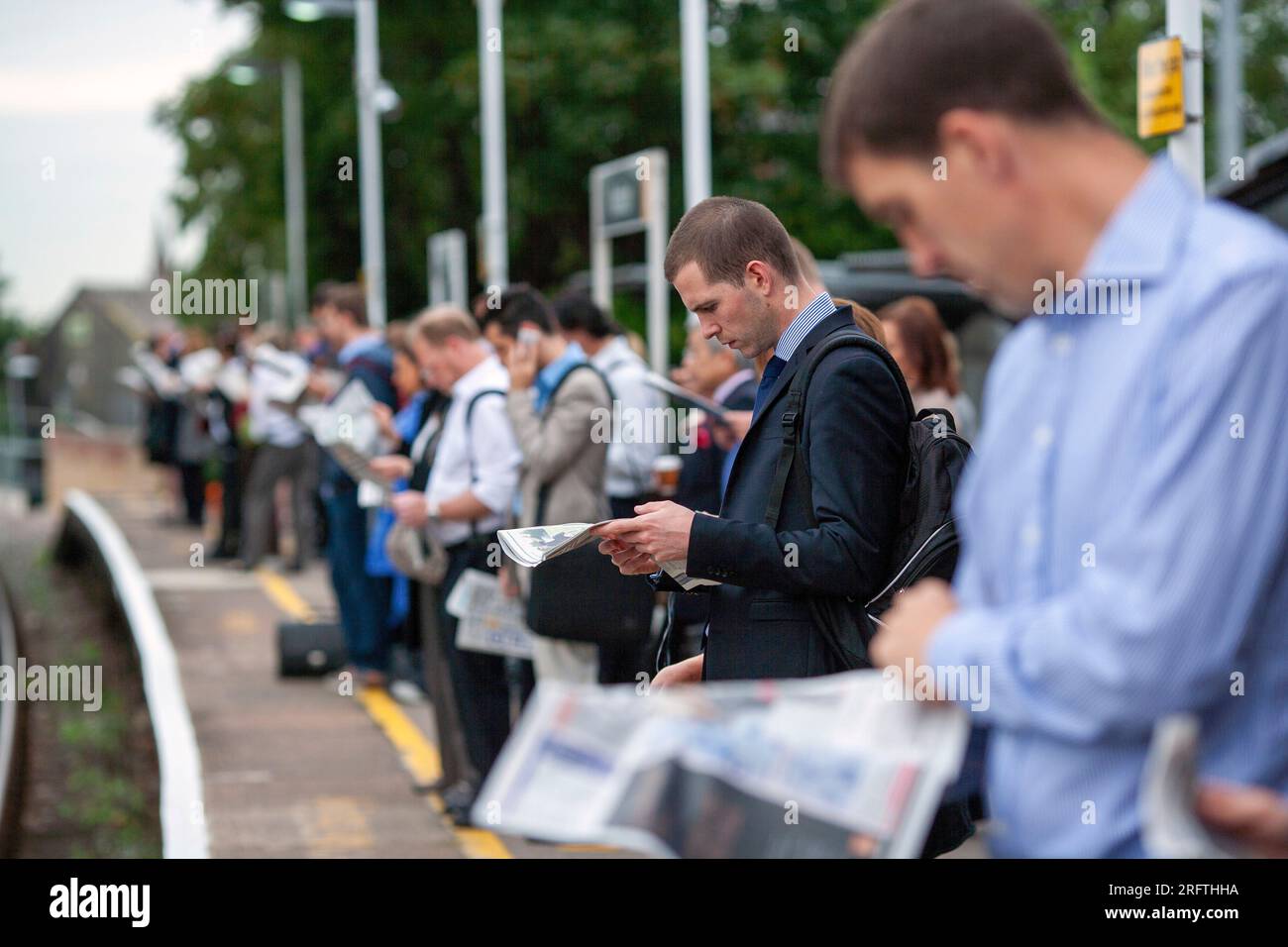 I pendolari aspettano sul binario della stazione ferroviaria di Norbiton . Tragitto per Londra , Regno Unito . Foto Stock