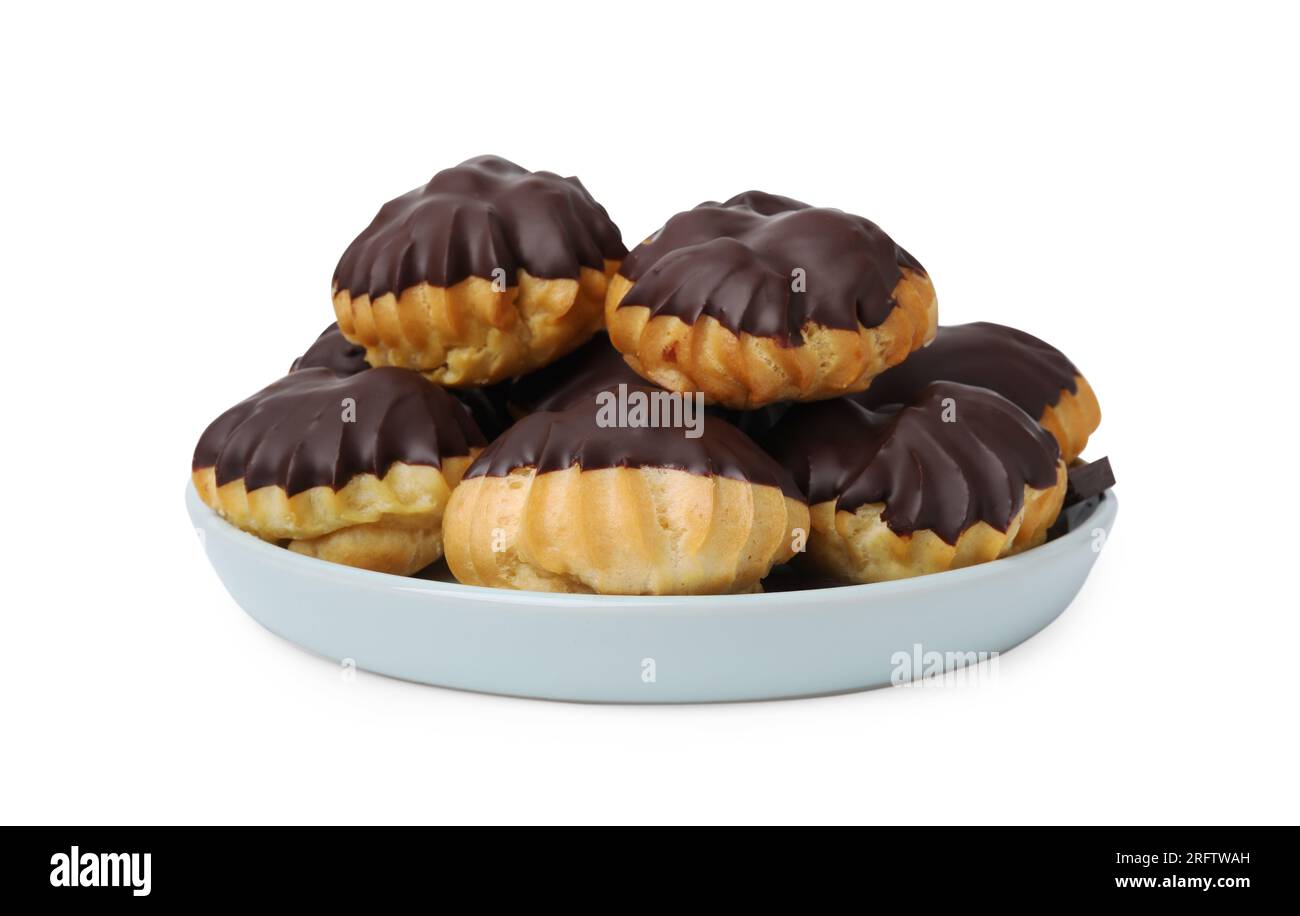 Deliziosi profiteroles con cioccolato sparso isolato su bianco Foto Stock