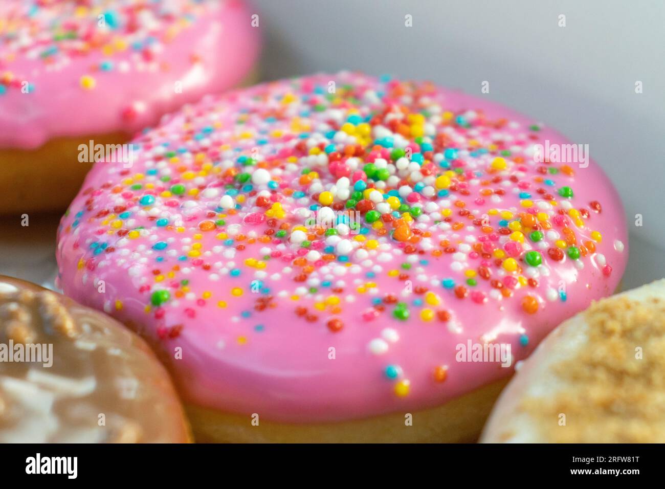 Le ciambelle colorate vengono posizionate in modo organizzato, dopo alcune modifiche. Foto Stock