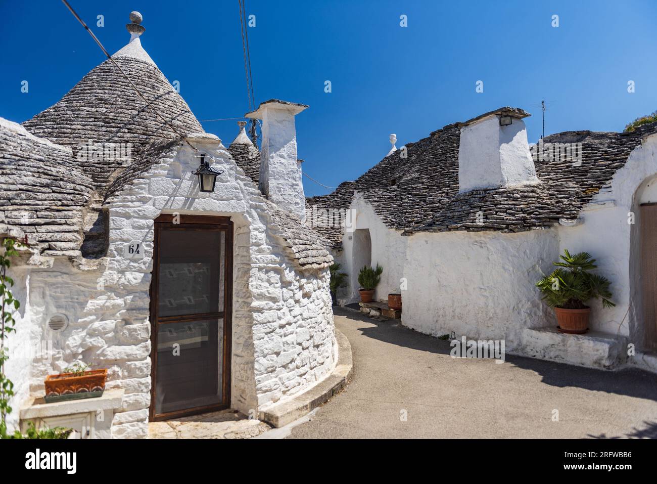ITALIA, PUGLIA, TRULLIS DEL VILLAGGIO DI ALBEROBELLO, PATRIMONIO MONDIALE DELL'UNESCO. I TRULLI SONO ABITAZIONI IN PIETRA A SECCO. QUESTI SONO ESEMPI NOTEVOLI Foto Stock