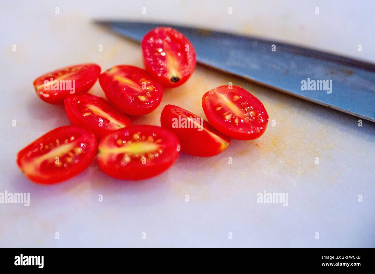 Pomodori a fette con il coltello posto sulla tavola Foto Stock