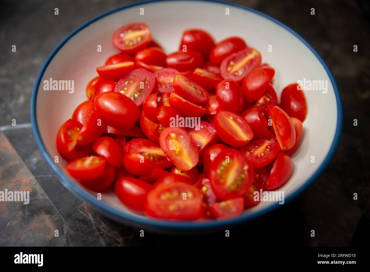 Ciotola di piccoli pomodori a fette rossi Foto Stock