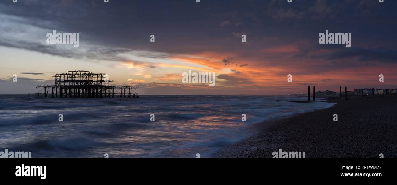 Brighton Old Pier e spiaggia con panorama al tramonto Foto Stock