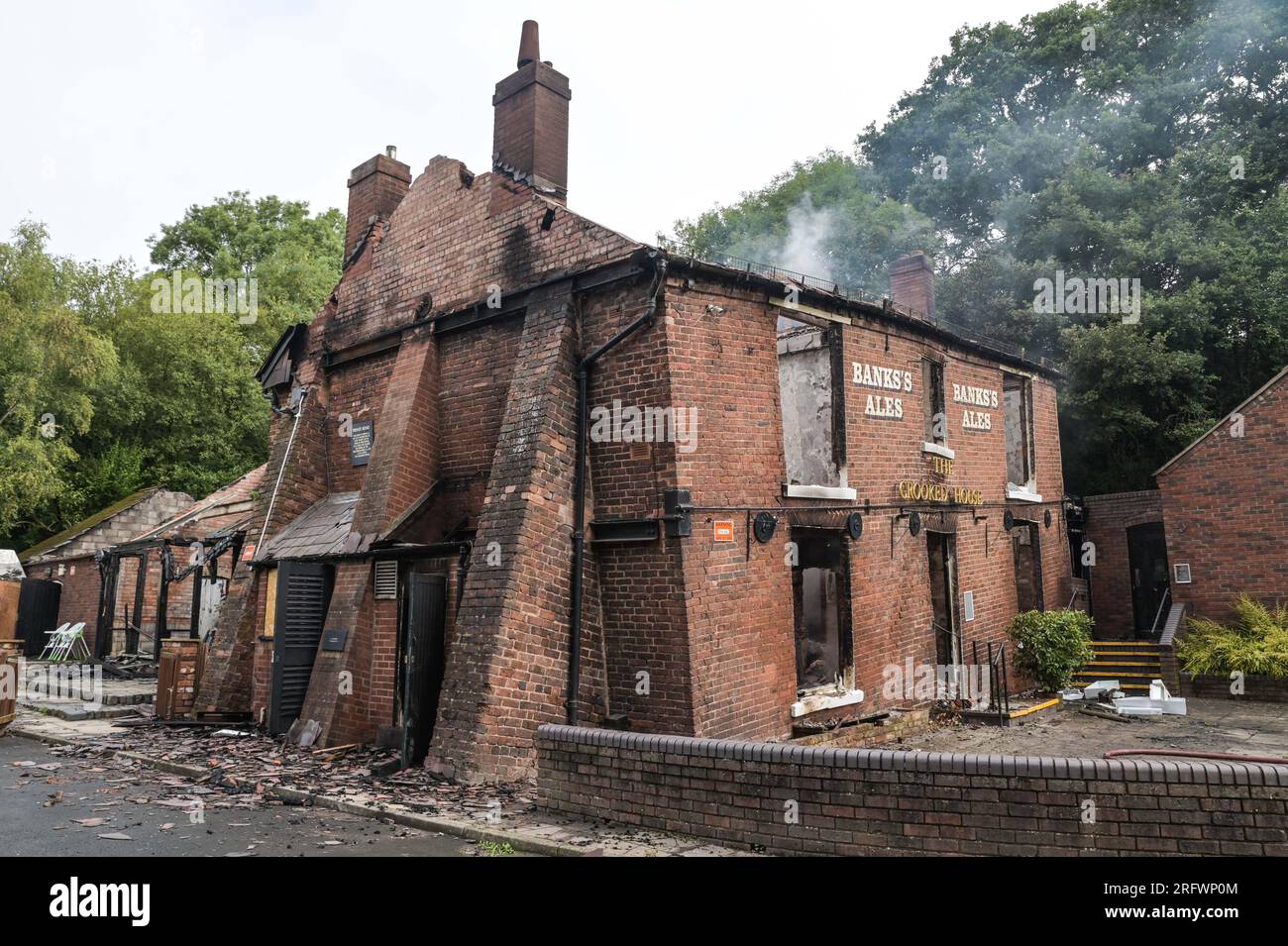 Himley Road, Himley, 6 agosto 2023: I resti bruciati del pub Crooked House che è stato acceso intorno alle 22 di sabato sera. - West Midlands e Staffordshire Fire and Rescue Service sono stati chiamati alle 22 di sabato sera, dopo che la Crooked House è stata incendiata. L'ex boozer si trovava a Himley (Staffordshire) vicino alla città di Dudley. L'incendio ha strappato il pub wonky del XVIII secolo che era stato commercializzato per 192 anni fino alla sua chiusura nel mese di luglio. L'edificio vantava un effetto pendente unico che causava diverse illusioni ottiche, tra cui marmi che sembravano arrotolarsi Foto Stock