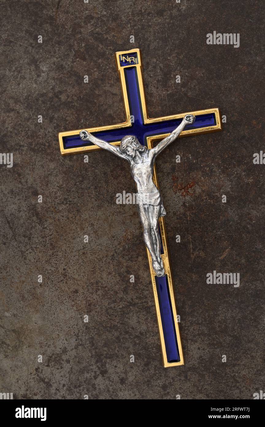 Crocifisso in ottone con smalto blu con Gesù Cristo in argento adagiato su metallo satinato Foto Stock