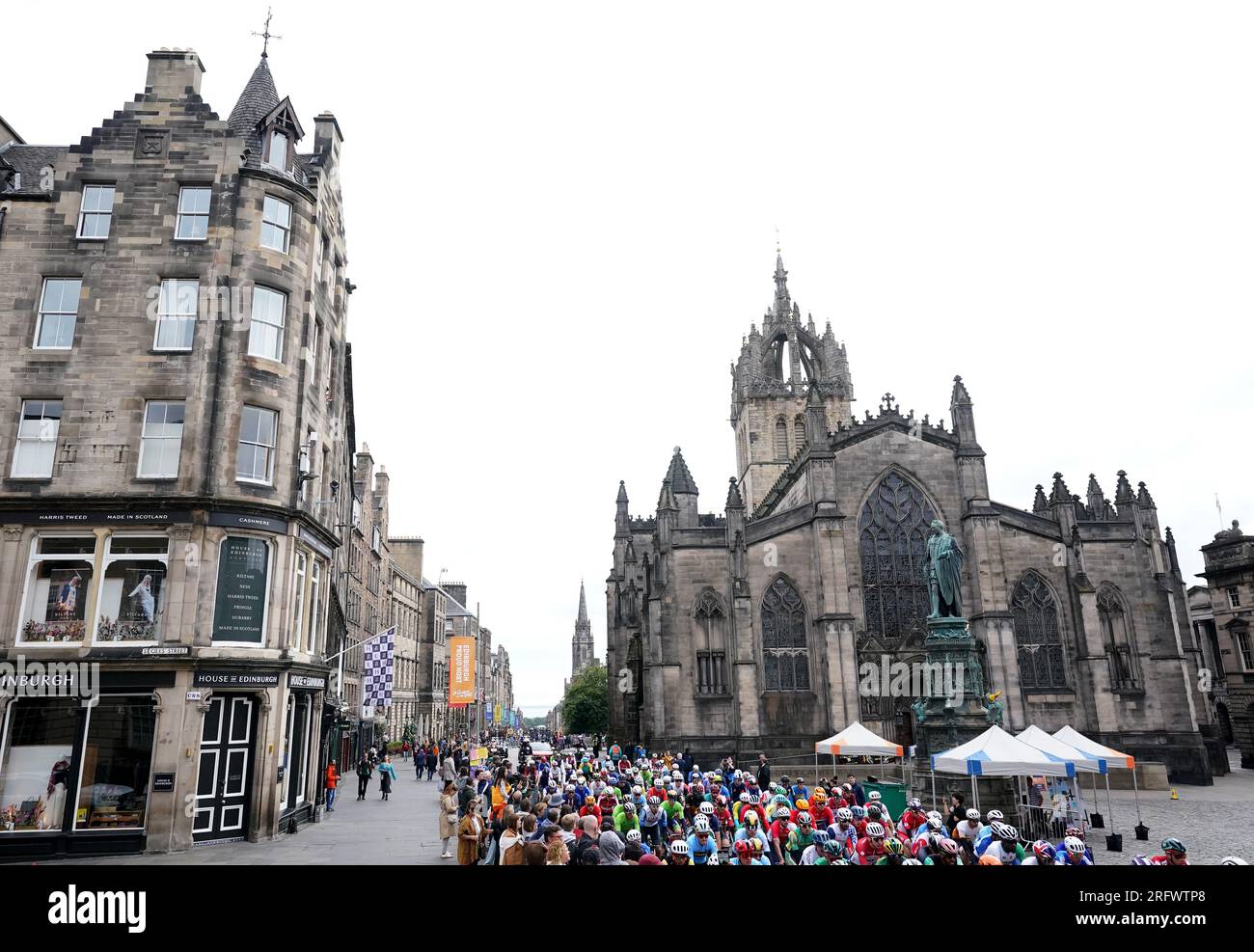 Il peloton passa davanti alla Cattedrale di St Giles a Edimburgo all'inizio della gara di ciclismo su strada Elite maschile durante il quarto giorno dei Campionati del mondo di ciclismo UCI 2023 a Edimburgo. Data foto: Domenica 6 agosto 2023. Foto Stock