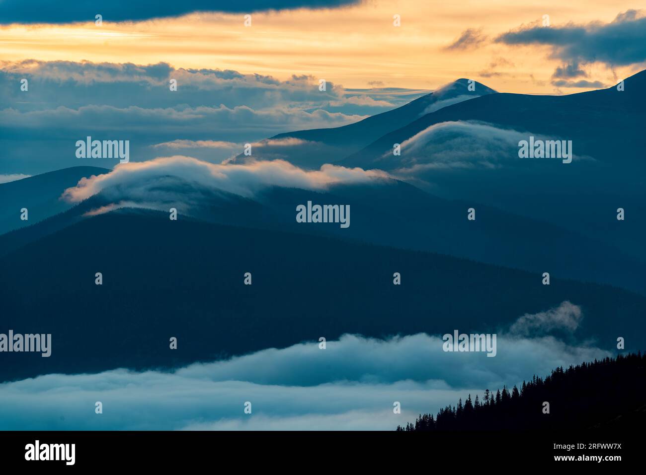 Colline ondulate e valli nebbiose nei Carpazi. Paesaggio panoramico all'aperto Foto Stock