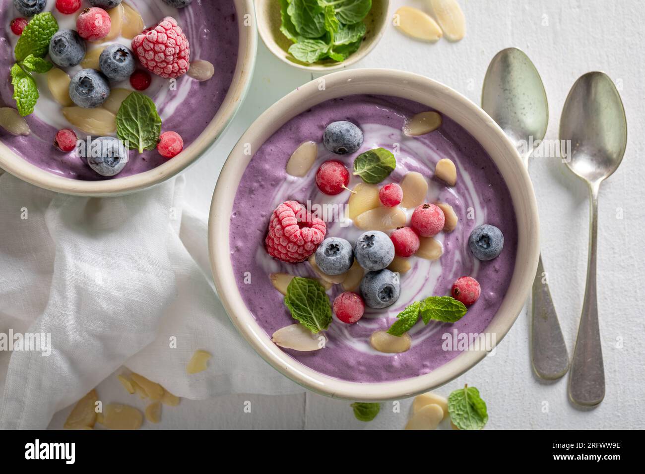 Zuppa vegana e panna dolce come antipasto estivo. Zuppa fredda con frutti di bosco per l'estate. Foto Stock