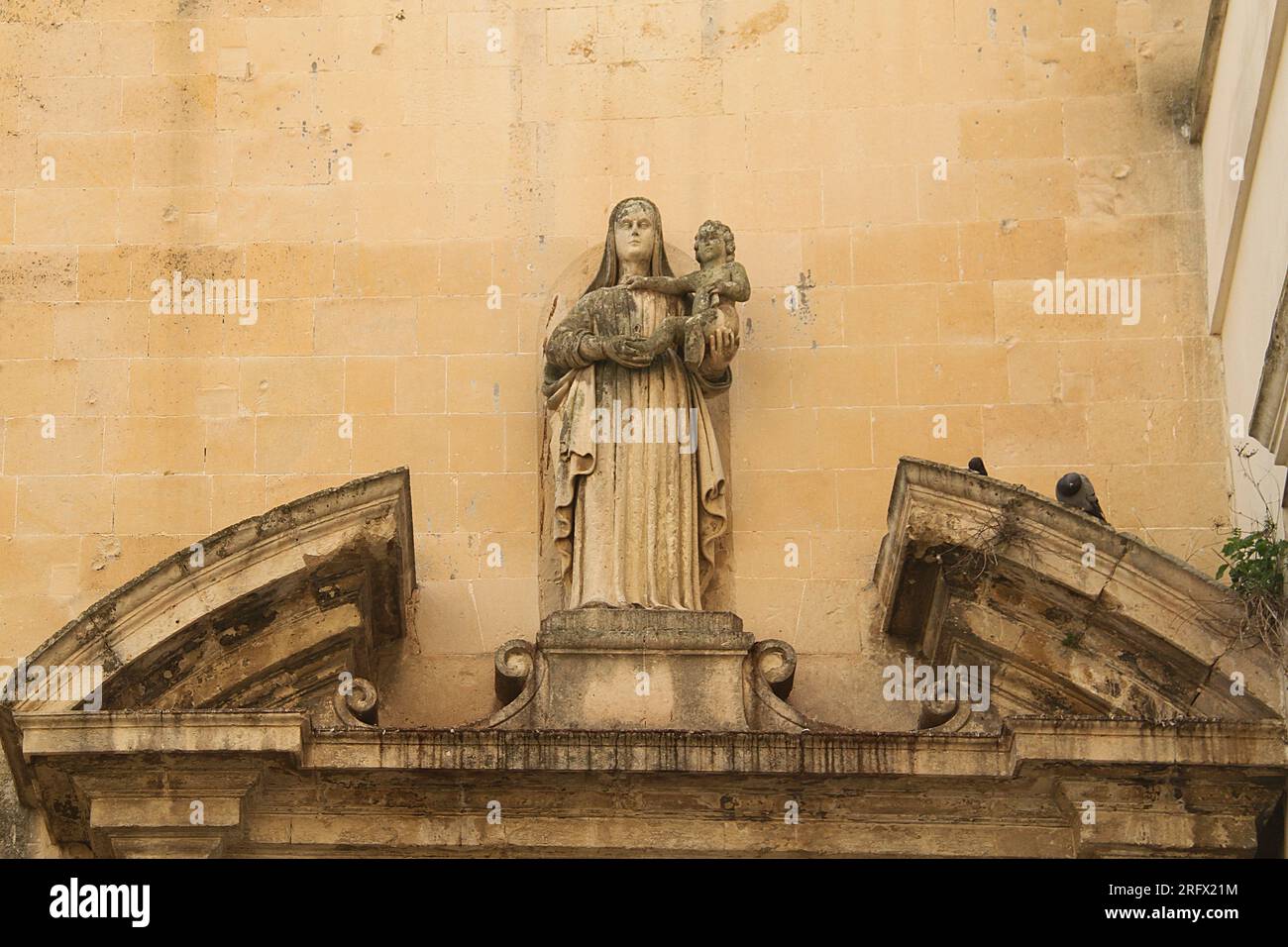 Lecce, Italia. Una Madonna scolpita con Gesù bambino che decora un portale nel centro storico. Foto Stock