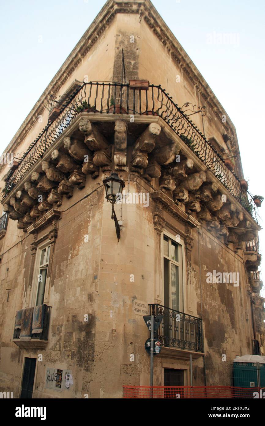 Lecce, Italia. Edificio nel centro storico con balcone sorretto da cornici. Foto Stock