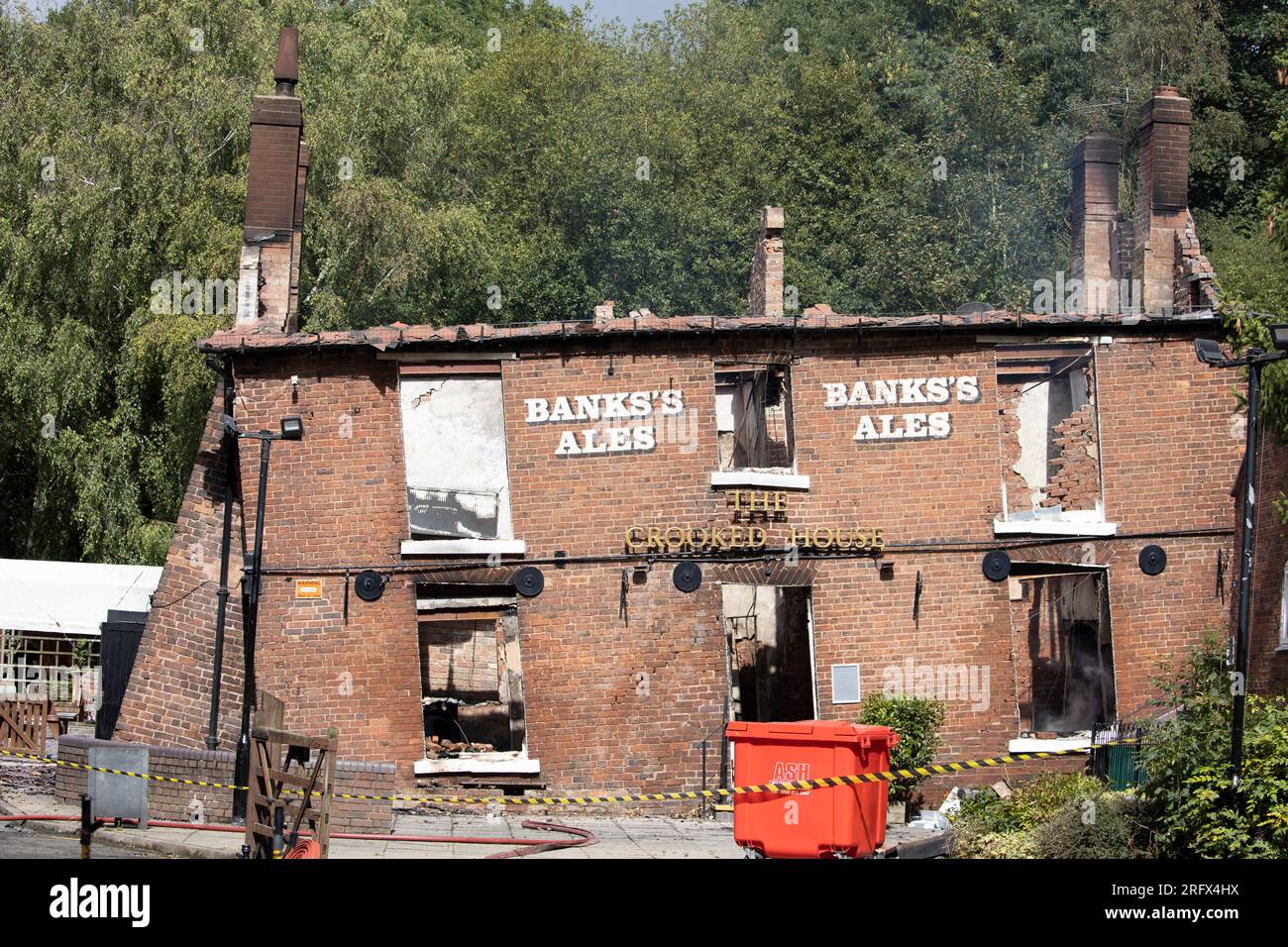 Himley Road, Himley, 6 agosto 2023: Il pub Crooked House che è stato acceso intorno alle 22 di sabato sera. Queste foto sono state scattate poco dopo che West Midlands e Staffordshire Fire and Rescue Service sono partiti domenica mattina. L'ex boozer si trovava a Himley (Staffordshire) vicino alla città di Dudley. L'incendio ha strappato il pub wonky del XVIII secolo che era stato commercializzato per 192 anni fino alla sua chiusura nel mese di luglio. L'edificio vantava un effetto pendente unico che causava diverse illusioni ottiche tra cui marmi che sembravano rotolare verso l'alto. Foto Stock