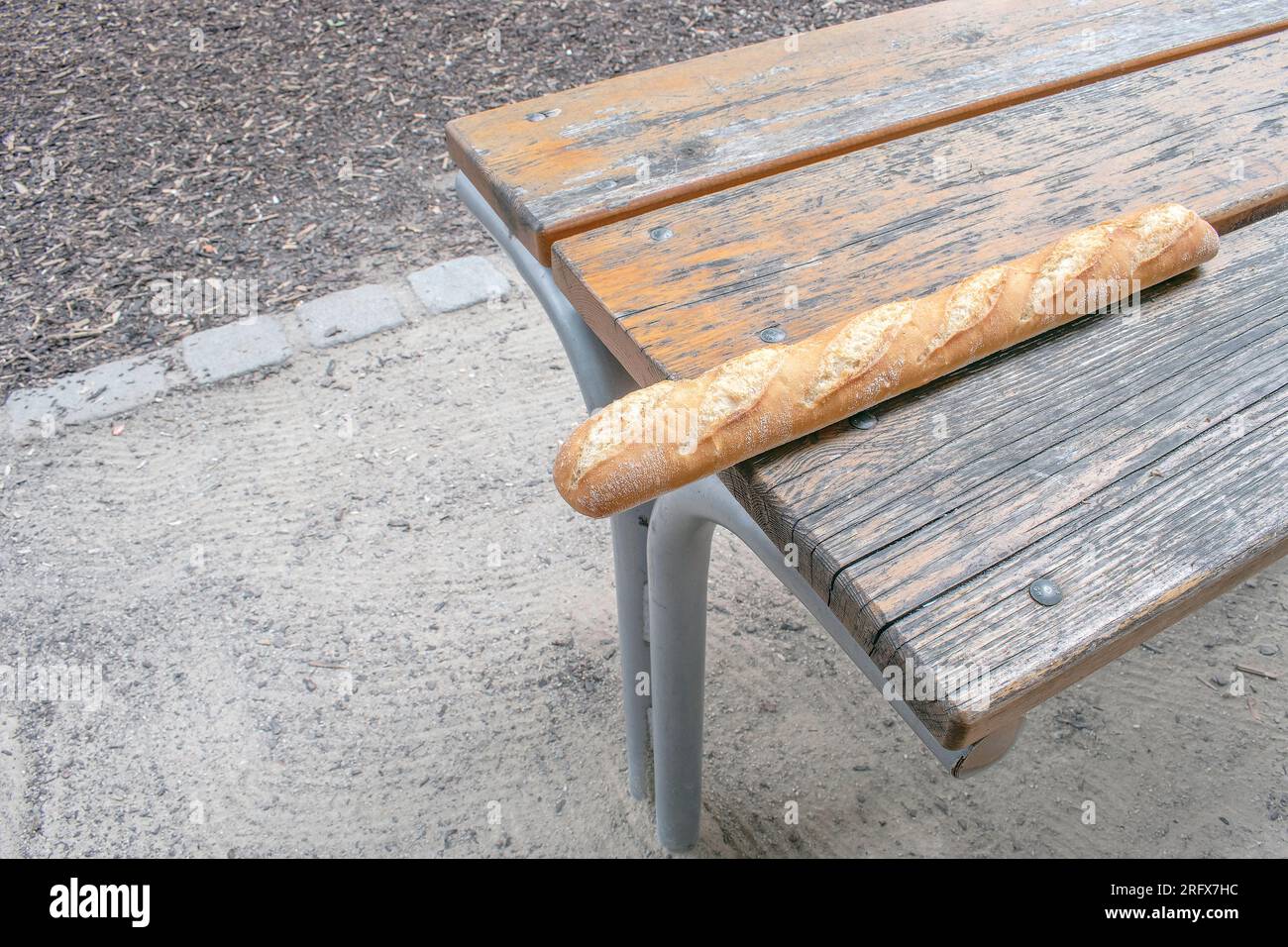 Baguette croccanti: Una deliziosa foto di stock, con una baguette lunga e croccante posizionata su un tavolo. Perfetto per rappresentare il tempo libero, dini all'aperto Foto Stock