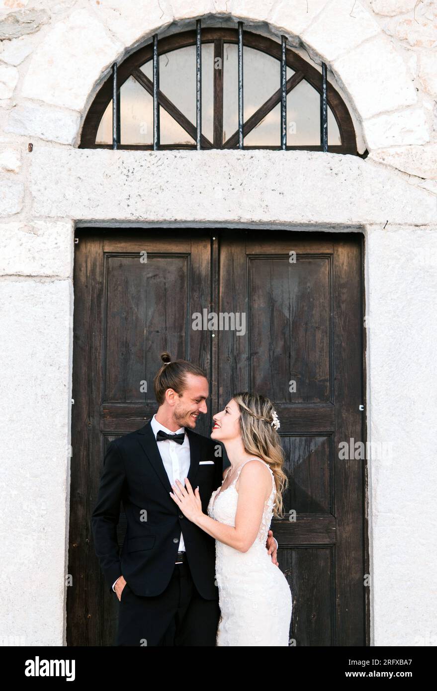 Ein Brautpaar vor einem traditionellen und retro Gebäude a Griechenland Foto Stock