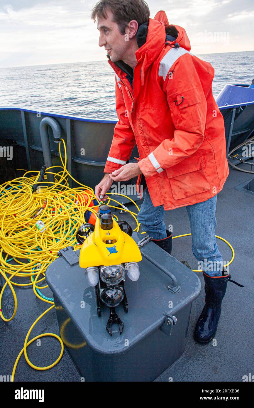 Scienziato marittimo che prepara un mini-Rov sottomarino in miniatura azionato a distanza. Foto Stock