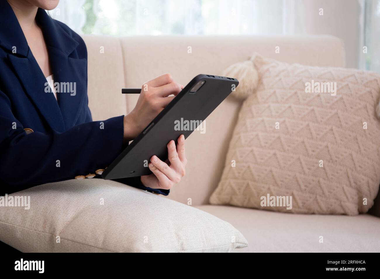 Closeup Hands giovane donna d'affari asiatica seduta sul divano che utilizza un tablet per pianificare un business di successo in salotto a casa, ufficio, lavoro Foto Stock