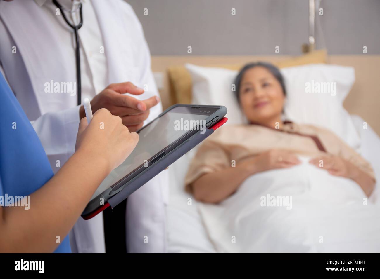 Closeup mani infermiere scrittura rapporto medico e assistenza sanitaria su tablet mentre medico specialista spiegare e controllare e diagnostica con paziente anziano Foto Stock