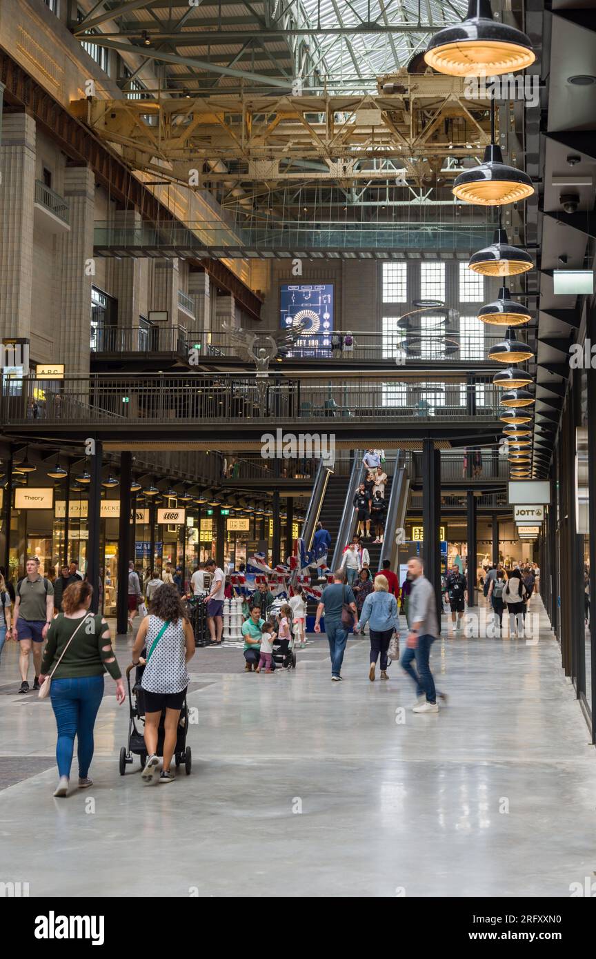 All'interno della centrale elettrica di Battersea, che mostra persone che camminano davanti alle unità di vendita al dettaglio nell'ambito della riqualificazione, Londra, Regno Unito Foto Stock