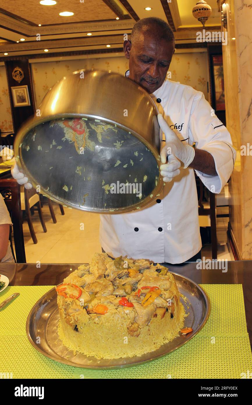 Cook serve Chicken Maqluba - Upside Down Chicken - un pasto preferito giordano Foto Stock