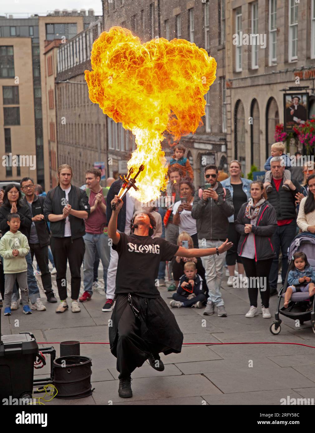 Edinburgh Festival Fringe Street performances, Scozia, Regno Unito. 6 agosto 2023. High Street Royal Mile, Tron e The Mound avevano artisti di strada professionisti che facevano autobus, alcuni più caldi grazie al fuoco e agli attori di spettacoli che promuovevano le loro performance. Il tempo era più gentile con una temperatura di circa 21 gradi centigradi una volta che il sole è apparso, anche se c'era una doccia pesante nel tardo pomeriggio. Nella foto: Hachikun lancia una palla di fuoco sul campo di Tron. Credito: Notizie dal vivo Archwhite/alamy. Foto Stock