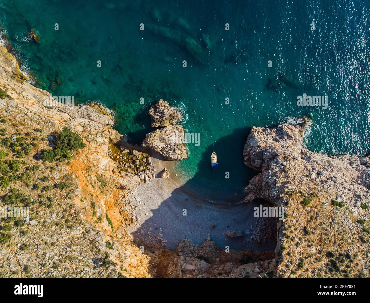 Vista dall'alto di uno splendido porto sul mare. Laguna con acqua blu scuro. Onde vicino alla costa rocciosa Foto Stock