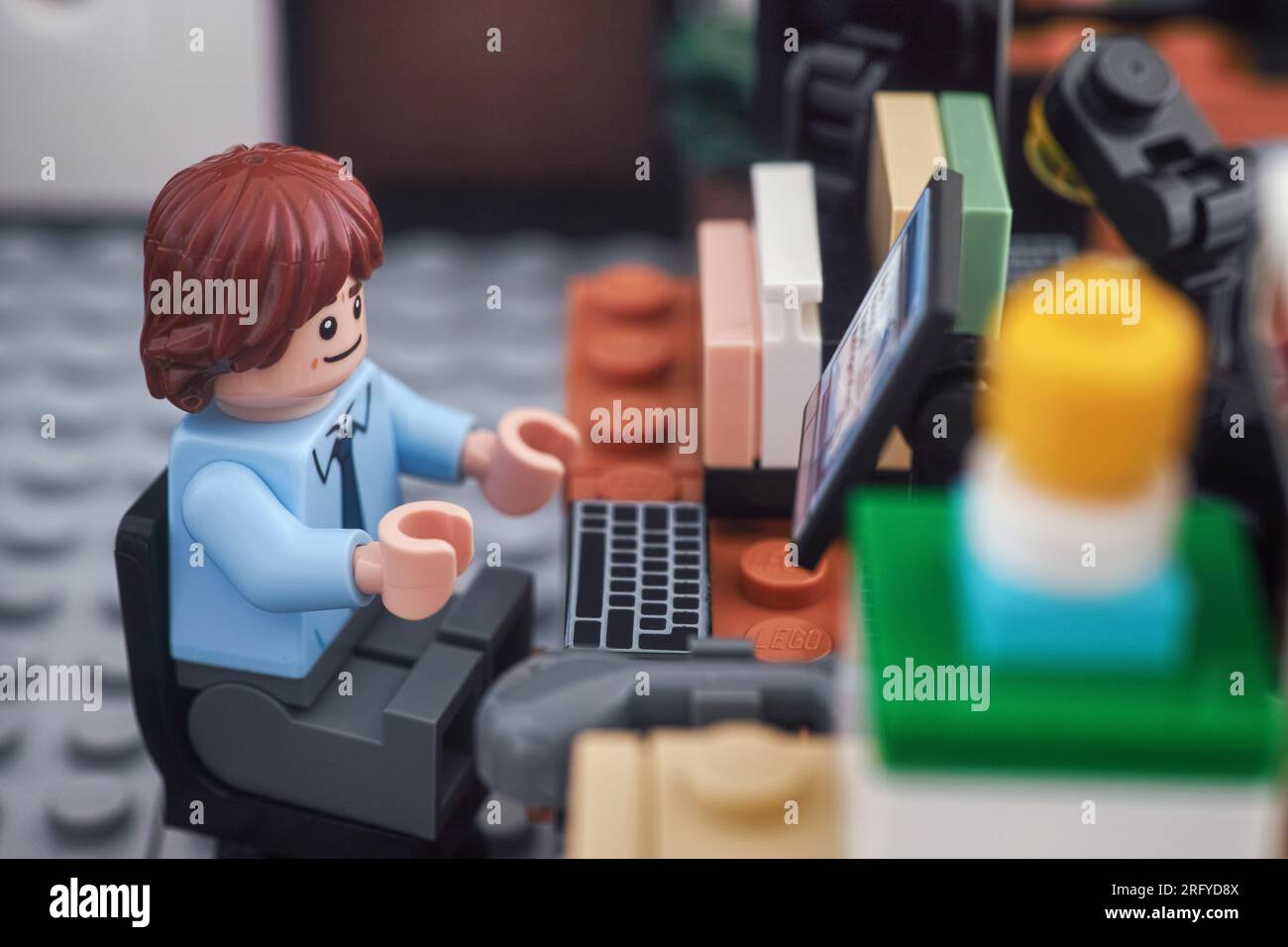 Tambov, Federazione Russa - 4 agosto 2023 Una minifigura d'affari Lego che lavora su un computer in un ufficio. Primo piano. Foto Stock