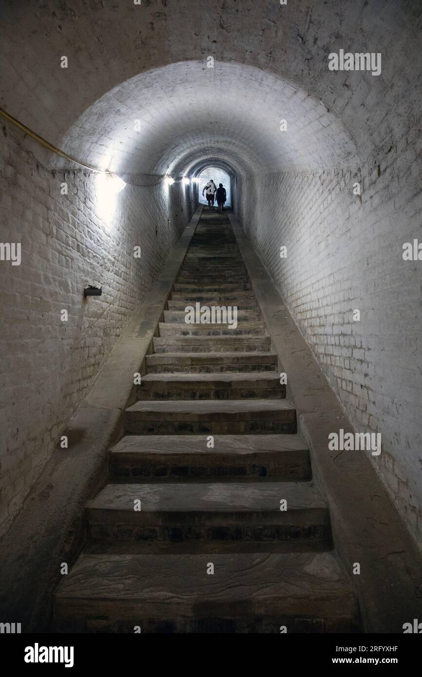 Scale di pietra all'interno di un tunnel al forte Drop Redoubt, dover, Inghilterra, con un gruppo di persone in cima. Foto Stock