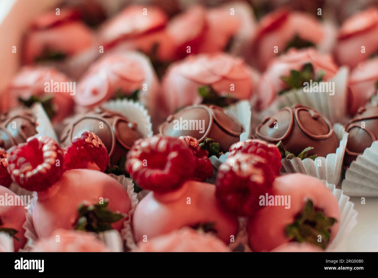 Dettagli di fragole ricoperte di cioccolato rosa. Collezione di caramelle dolci. Gustoso set per le vacanze Foto Stock